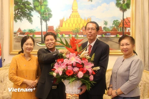 Đại sứ Lê Quý Quỳnh (trái) tặng hoa chúc Đại sứ Houmdaophone Soukhaseum nhân dịp quốc khánh lần thứ 43 của Lào. (Ảnh: Lê Hòa/Vietnam+)