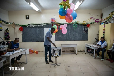 Cử tri bỏ phiếu tại một điểm bầu cử trong cuộc bầu cử Tổng thống ngày 30/12/2018. (Ảnh: AFP/TTXVN)