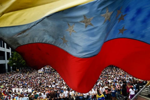 Những người ủng hộ lực lượng đối lập Venezuela tuần hành phản đối Chính phủ tại thủ đô Caracas ngày 23/1. (Ảnh: AFP/TTXVN)