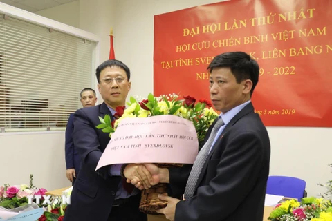 Tổng lãnh sự Ngô Phương Nghị (trái) tặng hoa chúc mừng Đại hội thành công. (Ảnh Dương Trí/TTXVN)