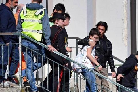 Các em học sinh được cảnh sát giải cứu an toàn khỏi chiếc xe buýt trường học bị lái xe bắt cóc và phóng hỏa ở Cremona, miền Bắc Italy. (Ảnh: EFE/TTXVN)