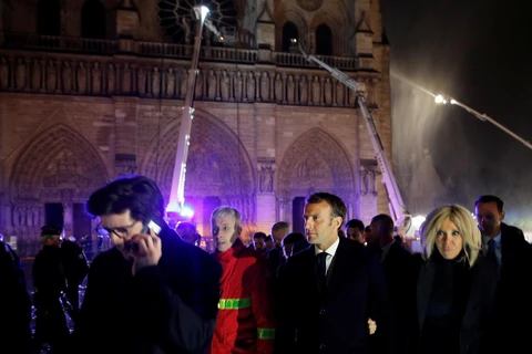 Tổng thống Pháp Emmanuel Macron cùng phu nhân thị sát hiện trường vụ cháy Nhà thờ Đức Bà ở Paris tối 15/4/2019. (Ảnh: AFP/TTXVN)