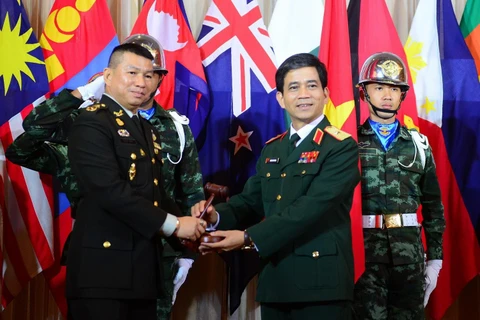 Trưởng đoàn Việt Nam, thiếu tướng Hoàng Kim Phụng, Cục trưởng Cục Gìn giữ Hòa bình tiếp nhận cương vị chủ tịch AAPTC năm 2020 từ Thái Lan. (Ảnh: Hữu Kiên/TTXVN)