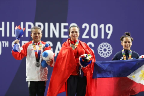 Vương Thị Huyền (giữa) trên bục nhận huy chương vàng nội dung cử tạ 45kg nữ. (Ảnh Hoàng Linh/TTXVN)