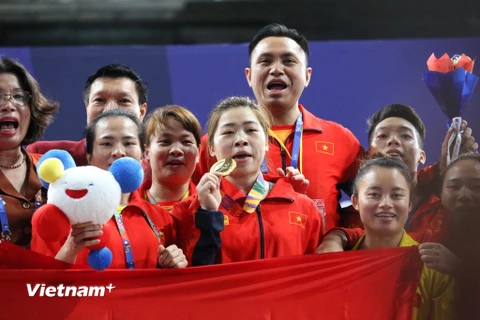 Hoàng Thị Duyên ăn mừng cùng đội tuyển Cử tạ sau khi giành HCV SEA Games 30. (Ảnh: Trần Giáp/Vietnam+)