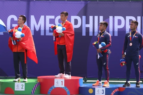 Daniel Cao Nguyễn (trái) và Lý Hoàng Nam (thứ 2 từ trái qua) thực hiện nghii thức chào cờ tại lễ trao giải. (Ảnh: Hoàng Linh/TTXVN)