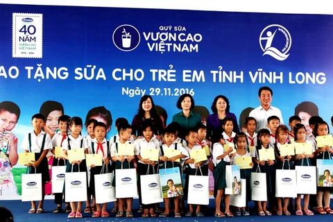 Các đại biểu trao tặng sữa cho các em học sinh trường tiểu học Hoà Bình A, xã Hoà Bình, Huyện Trà Ôn, Tỉnh Vĩnh Long.