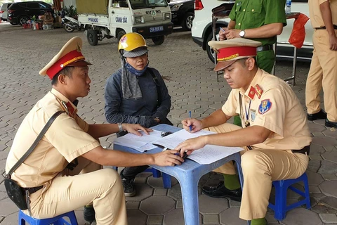 Cảnh sát giao thông kiểm tra đối với lái xe vận chuyển 19 khẩu súng tự chế (Ảnh: PV/Vietnam+) 