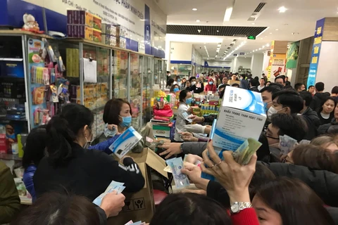 Kinh hoàng cảnh tượng chen lấn, tranh giành nhau mua hộp khẩu trang ở chợ thuốc Hapulico, Thanh Xuân, Hà Nội. (Ảnh: Sơn Bách/Vietnam+)