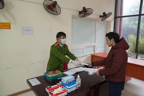 Để phòng chống dịch 2019-nCoV, người dân đến làm việc tại Phòng Cảnh sát Phòng cháy chữa cháy và Cứu hộ Cứu nạn Hà Nội sẽ được cấp phát khẩu trang và găng tay miễn phí. (Ảnh: PV/Vietnam+) 