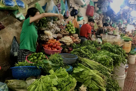 Giá rau xanh giảm khiến không chỉ người tiêu dùng mà tiểu thương tại các chợ cũng phấn khởi. (Ảnh: Việt Anh/Vietnam+)