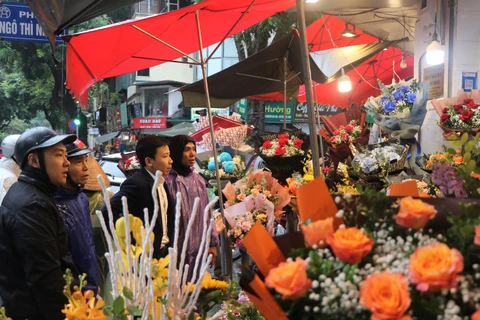 Bất chấp mưa nặng hạt tại một số khu vực trên địa bàn thành phố Hà Nội, lượng khách xếp hàng mua hoa tươi tại các cửa tiệm vẫn tăng mạnh. (Ảnh: Việt Anh/Vietnam+)