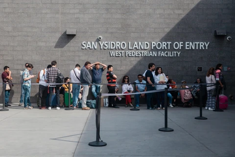 Người nhập cư xếp hàng tại cửa khẩu San Ysidro ở biên giới Mỹ-Mexico. (Ảnh: AFP/TTXVN)