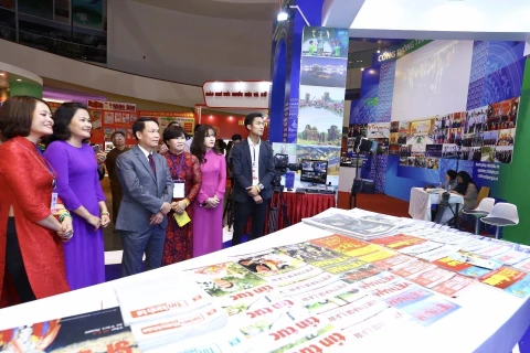 Tổng giám đốc TTXVN Nguyễn Đức Lợi xem gian trưng bày các ấn phẩm của TTXVN tại Hội báo toàn quốc 2019. (Ảnh: Minh Quyết – TTXVN)