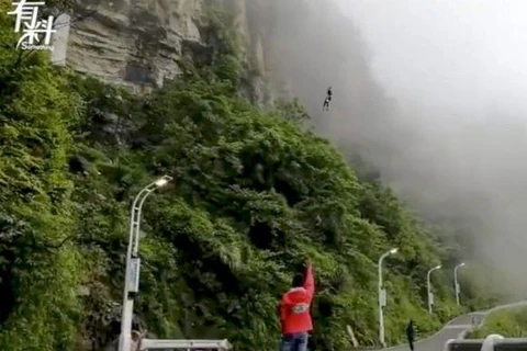 Wan Tiandi giao đồ ăn bằng cách nhảy từ trên núi. (Ảnh: Yahoo)