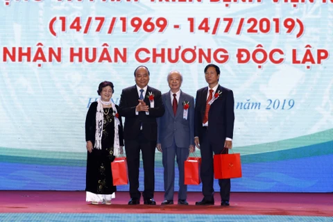 Thủ tướng Nguyễn Xuân Phúc tặng quà cho nguyên Giám đốc Bệnh viện Nhi Trung ương qua các thời kỳ. (Ảnh: Thống Nhất/TTXVN) 