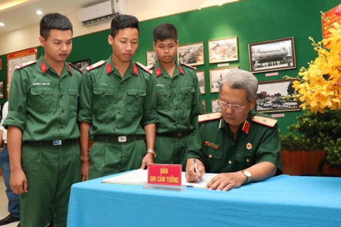 Thiếu tướng Nguyễn Văn Chương, Chủ tịch Hội Cựu chiến binh Thành phố Hồ Chí Minh viết cảm tưởng. (Ảnh: Xuân Khu/TTXVN) 