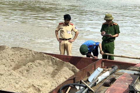 Lực lượng chức năng kiểm tra, xử lý các tàu hút cát trái phép trên sông Lam. (Ảnh: TTXVN phát) 