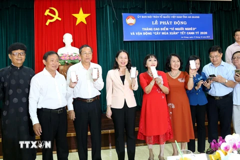 Lãnh đạo tỉnh An Giang cùng các đại biểu nhắn tin ủng hộ Quỹ Vì người nghèo qua Cổng thông tin điện tử nhân đạo Quốc gia. (Ảnh: Công Mạo/TTXVN)
