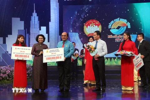 Chủ tịch Ủy ban MTTQ Việt Nam Thành phố Hồ Chí Minh Tô Thị Bích Châu tiếp nhận tượng trưng số tiền ủng hộ từ các nhà hảo tâm. (Ảnh: Xuân Khu/TTXVN)