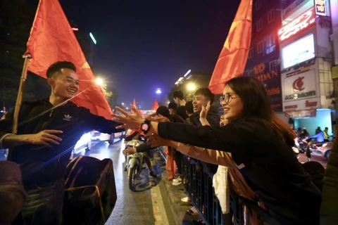 Hàng nghìn cổ động viên Việt Nam đổ ra đường ăn mừng chiến thắng tại các tuyến phố trung tâm Hà Nội. (Ảnh: TTXVN)