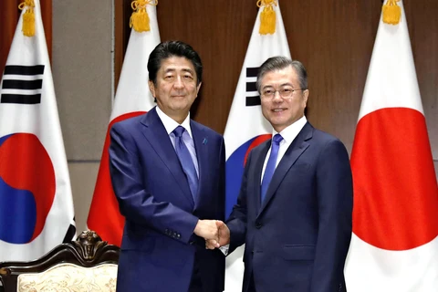 Tổng thống Hàn Quốc Moon Jae-in và Thủ tướng Nhật Bản Shinzo Abe. (Ảnh: Kyodo)