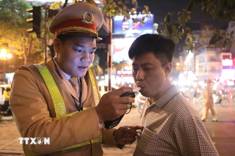 Cảnh sát giao thông kiểm tra nồng độ cồn tại ngã tư Lạc Trung-Thanh Nhàn. (Ảnh: Doãn Tấn/TTXVN)