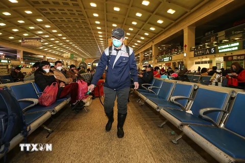 Nhân viên y tế phun thuốc khử trùng tại một nhà ga ở Trung Quốc. (Ảnh: AFP/TTXVN)