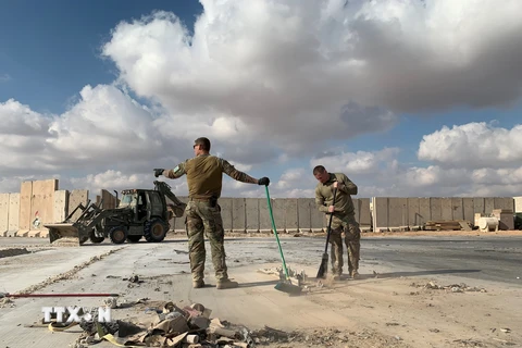 Binh sĩ Mỹ dọn dẹp đống đổ nát tại căn cứ không quân Ain al-Asad. (Ảnh: AFP/TTXVN)