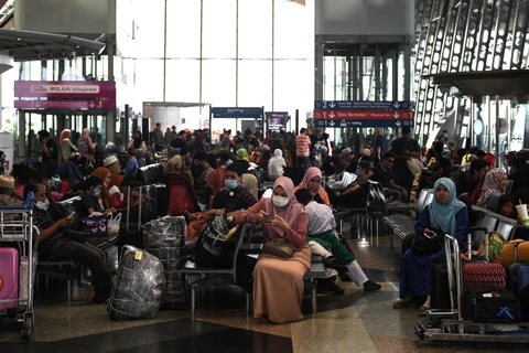 Người dân đeo khẩu trang phòng tránh lây nhiễm virus corona chủng mới tại sân bay quốc tế Kuala Lumpur. (Ảnh: AFP/ TTXVN)