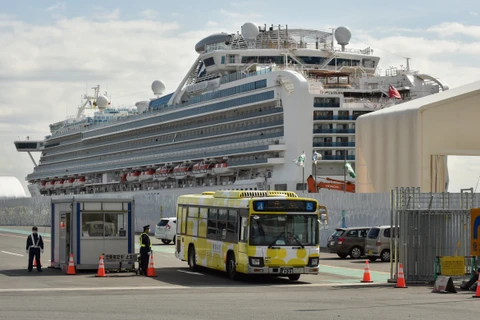Xe chở du khách rời tàu Diamond Princess. (Ảnh: AFP/TTXVN)