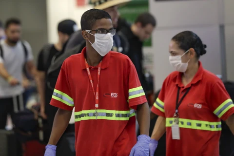Nhân viên hàng không đeo khẩu trang tại sân bay Sao Paulo. (Ảnh: AP)