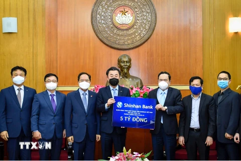 Ông Trần Thanh Mẫn tiếp nhận sự ủng hộ của Ngân hàng Shinhan Bank. (Ảnh: Dương Giang/TTXVN)