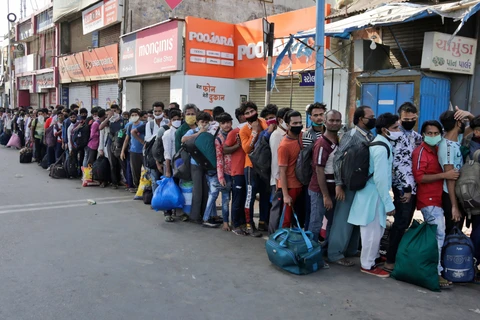Người lao động xếp hàng chờ lên tàu về nhà tại Ahmedabad, Ấn Độ. (Ảnh: AP)