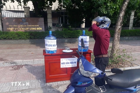 Điện lực Hà Nội cung cấp nước uống miễn phí cho người dân. (Ảnh: TTXVN)