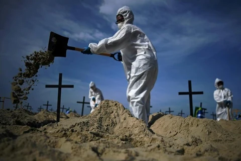 Các tình nguyện viên đào mộ trên bãi biển Copacabana. (Ảnh: AFP)