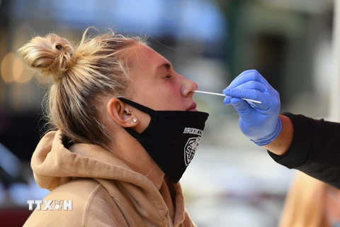 Nhân viên y tế lấy mẫu xét nghiệm COVID-19 cho người dân tại New York. (Ảnh: AFP/TTXVN)