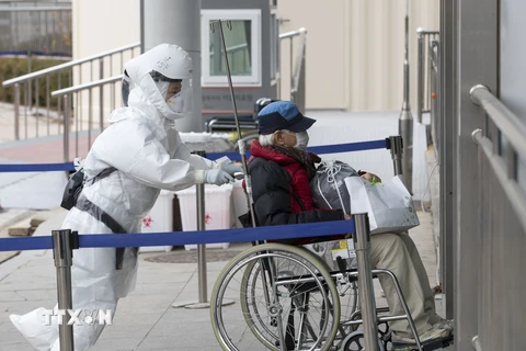 Nhân viên y tế chuyển bệnh nhân COVID-19 tới trung tâm y tế ở Seoul. (Ảnh: THX/TTXVN)