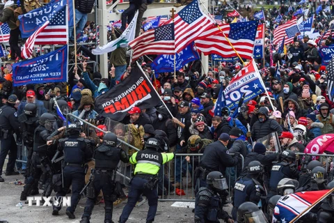Người biểu tình ủng hộ Tổng thống Donald Trump đối đầu với cảnh sát. (Ảnh: AFP/TTXVN)