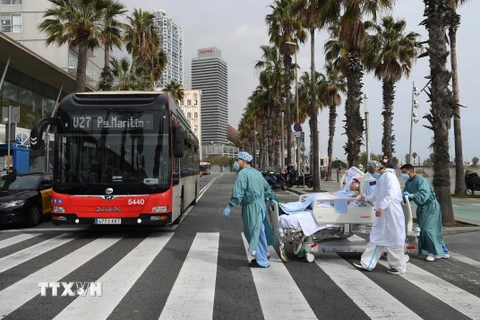 Chuyển bệnh nhân COVID-19 tới bệnh viện tại Barcelona. (Ảnh: AFP/TTXVN)
