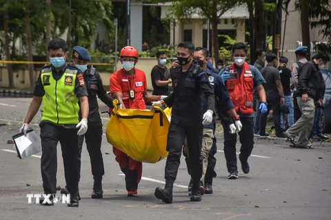 Cảnh sát di chuyển thi thể của nghi phạm đánh bom liều chết. (Ảnh: AFP/TTXVN)
