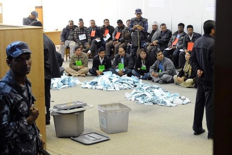Cảnh sát đứng gác khi các nhân viên Ủy ban Bầu cử chuẩn bị kiểm phiếu. (Nguồn: AFP)