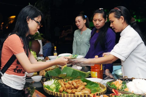 Du khách thưởng thức các món ăn đặc trưng của Quảng Bình khi tham gia lễ hội. Ảnh minh họa. (Ảnh: TTXVN)