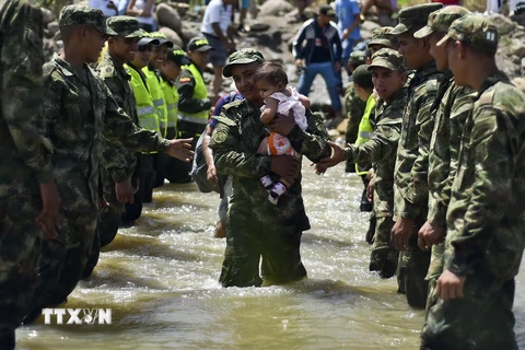 Binh sỹ hỗ trợ người dân Colombia rời Venezuela về nước tại khu vực cửa khẩu Cucuta ngày 27/8. (Ảnh: AFP/TTXVN)