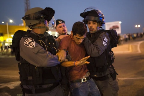 Cảnh sát Israel bắt giữ một thanh niên Palestine. (Ảnh: Reuters)