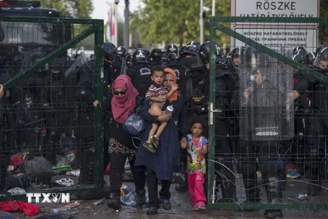 Cảnh sát Hungary ngăn chặn người di cư tại Roszke, gần biên giới với Serbia ngày 16/9. (Ảnh: Reuters/TTXVN)