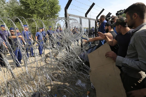 Dòng người di cư tìm cách vượt qua hàng rào dây thép gai để vào các quốc gia châu Âu. (Ảnh: Getty Images)