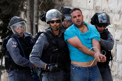 Cảnh sát Israel bắt giữ một người biểu tình Palestine trong cuộc đụng độ gần thánh đường Al-Aqsa. (Ảnh: Reuters)