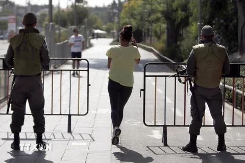 Binh sỹ Isreal gác tại lối vào một khu vực công cộng ở phía tây Jerusalem ngày 14/10. (Ảnh: AFP/TTXVN)