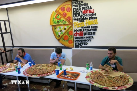 Một nhà hàng ở thủ đô Baghdad, Iraq đã tổ chức cuộc thi ăn bánh pizza. (Ảnh: THX/TTXVN)
